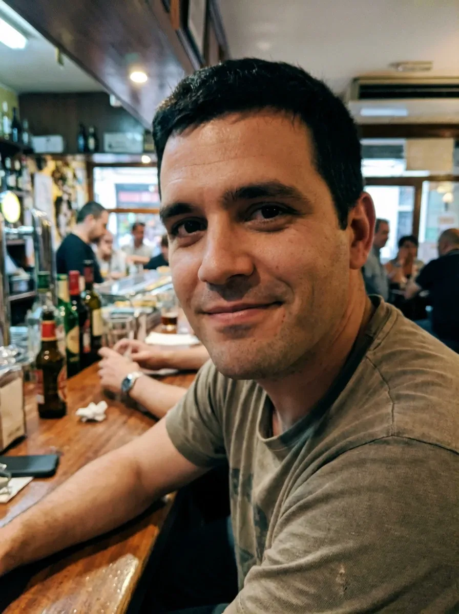 Original selfie input — man in an olive T-shirt at a cafe